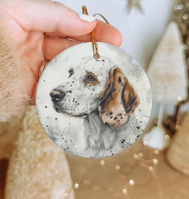 a hand holding a white and brown dog ornament
