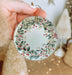 a person holding a christmas ornament in their hand