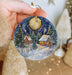 a person holding a christmas ornament in their hand