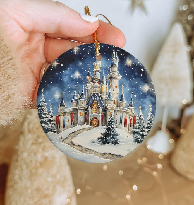 a hand holding a christmas ornament with a castle on it