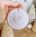 a person holding a paper rose ornament in their hand