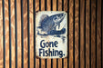 a gone fishing sign on a wooden wall