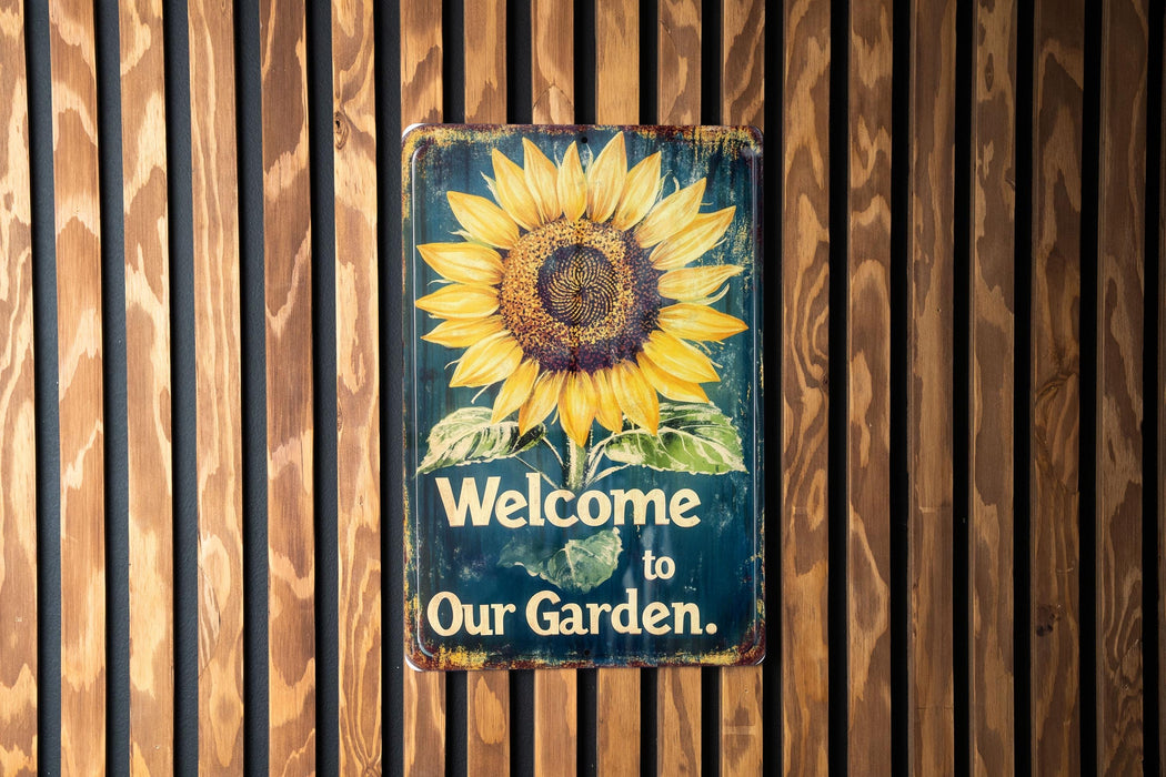 a welcome to our garden sign on a wooden wall