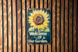a welcome to our garden sign on a wooden wall