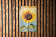 a painting of a sunflower on a wooden wall