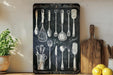 a chalkboard with a bunch of kitchen utensils on it