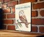 a picture of an owl on a sign on a brick wall