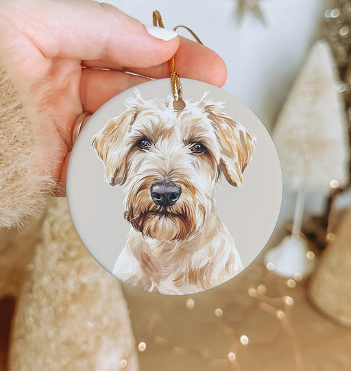 a hand holding a christmas ornament with a picture of a dog