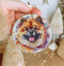 a person holding a dog ornament in their hand