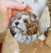 a person holding a dog ornament in their hand