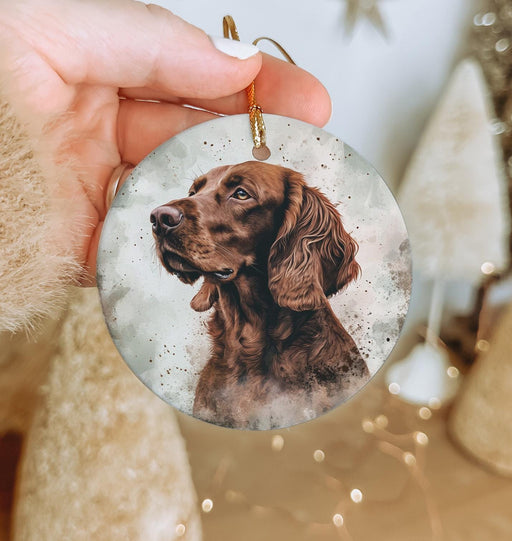 a person holding a christmas ornament with a dog on it