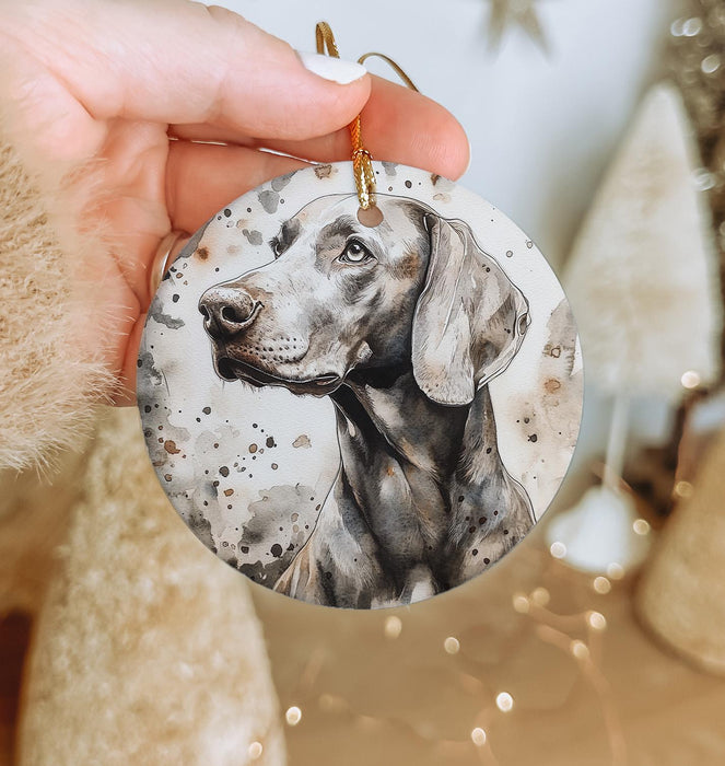 a hand holding a christmas ornament with a picture of a dog