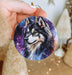 a person holding a small ornament with a wolf on it