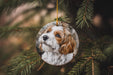 a brown and white dog ornament hanging from a christmas tree