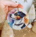 a person holding a dog ornament in their hand