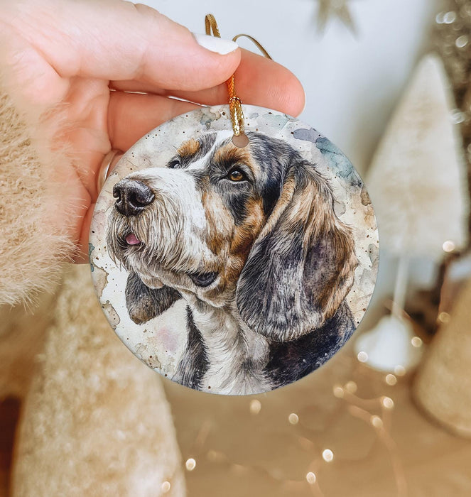 a hand holding a christmas ornament with a picture of a dog