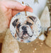 a hand holding a christmas ornament with a picture of a dog