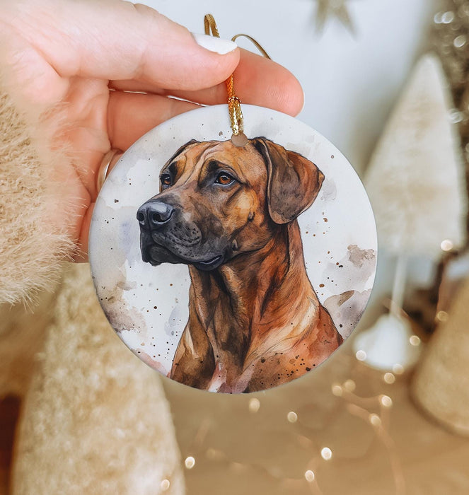 a hand holding a christmas ornament with a dog on it