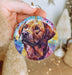 a hand holding a round ornament with a picture of a dog on it