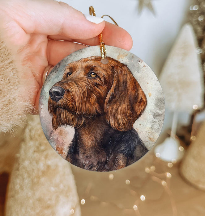 a hand holding a christmas ornament with a dog on it