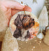 a hand holding a christmas ornament with a picture of a dog