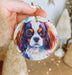 a person holding a dog ornament in their hand