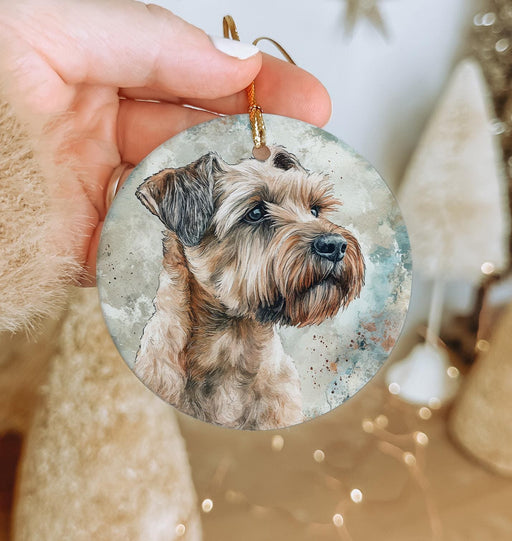 a hand holding a christmas ornament with a picture of a dog