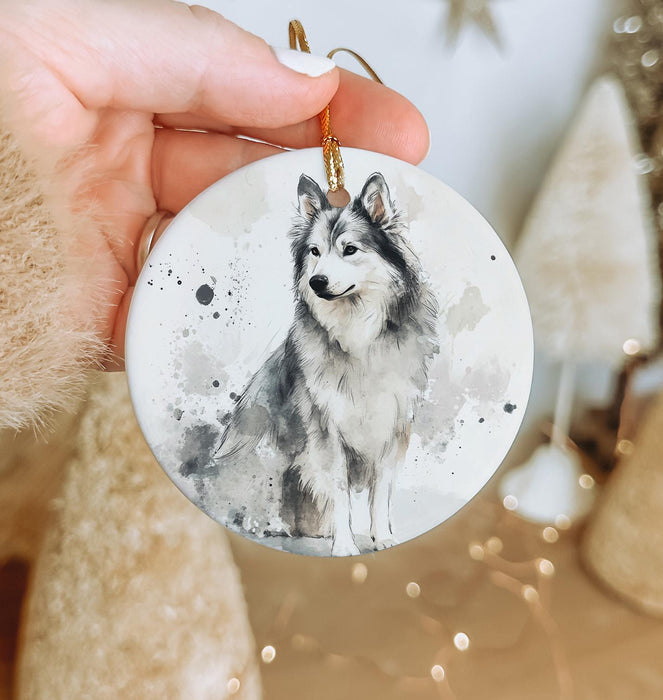 a hand holding a ceramic ornament with a picture of a dog