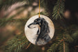 a black and white dog ornament hanging from a christmas tree