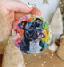 a person holding a dog ornament in their hand