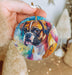 a person holding a dog ornament in their hand