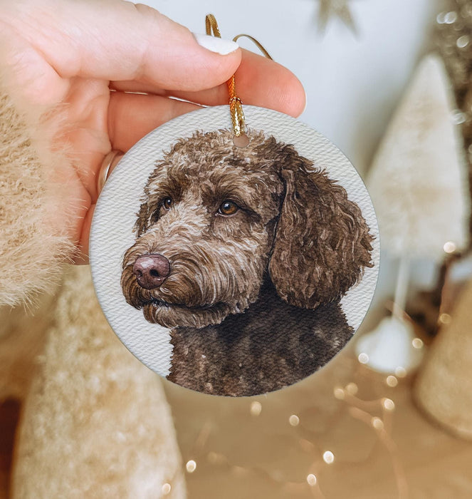 a hand holding a christmas ornament with a picture of a dog