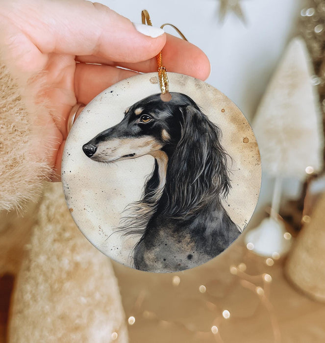 a hand holding a christmas ornament with a dog on it