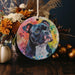 a painting of a dog on a round ornament