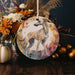 a picture of a dog on a round ornament