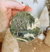 a person holding a christmas ornament in their hand