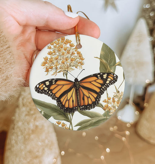 a hand holding a glass ornament with a butterfly on it