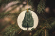 a christmas ornament with a picture of a tree on it