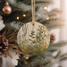 a ceramic ornament hanging from a christmas tree