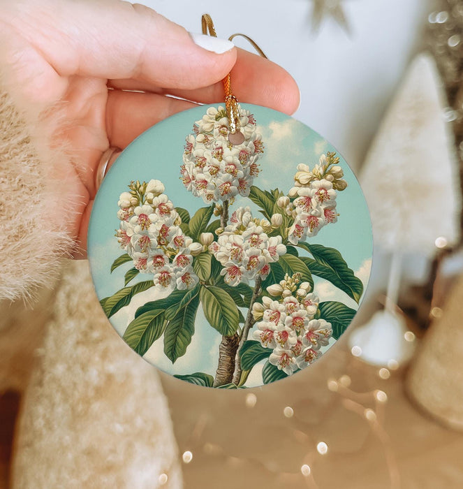 a person holding a round ornament with flowers on it