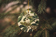a ceramic ornament hanging from a christmas tree