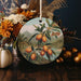 a ceramic ornament with a painting of oranges on it