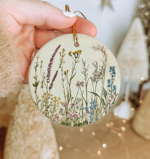 a person holding a round ornament with flowers on it
