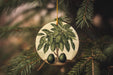 an ornament with two avocados hanging from a tree