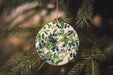 a ceramic ornament hanging from a christmas tree