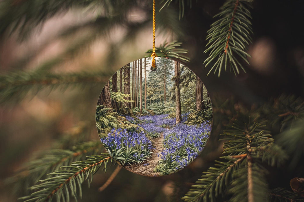 a circular ornament hanging from a tree filled with blue flowers