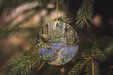 a circular ornament hanging from a tree filled with blue flowers