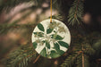 a ceramic ornament hanging from a christmas tree