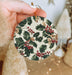 a person holding a christmas ornament in their hand