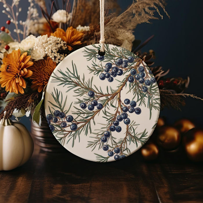 a white ceramic ornament with blue berries on it